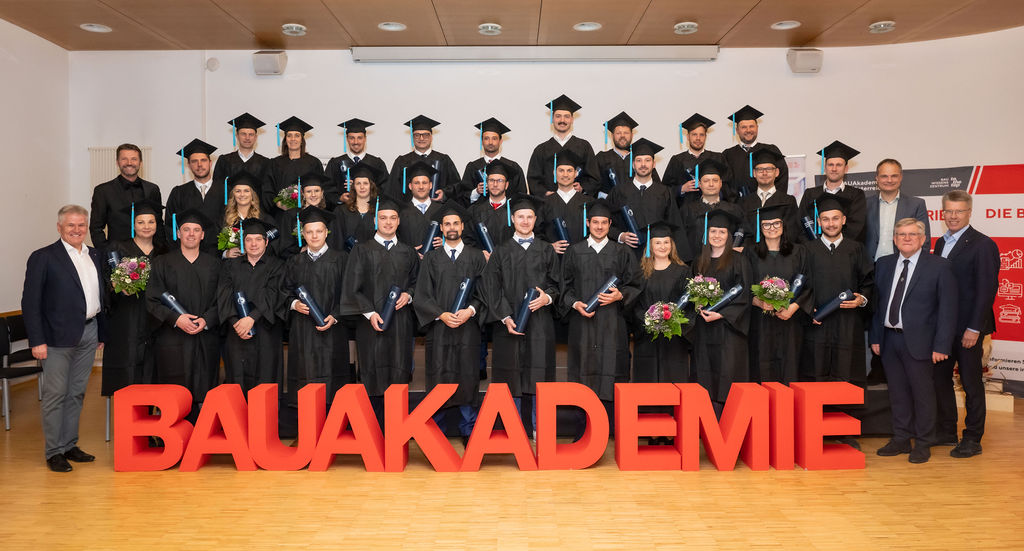 Graduierungfeier2025_Absolvent:innen-Gruppenfoto mit BAUAkademie Buchstaben